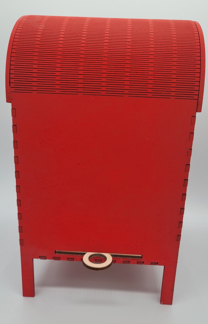 May include: Red wooden mailbox with a decorative top and a small wooden handle. The mailbox is on four legs.