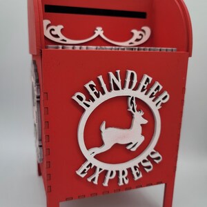 May include: Red wooden mailbox with a white reindeer and "Reindeer Express" written on it.
