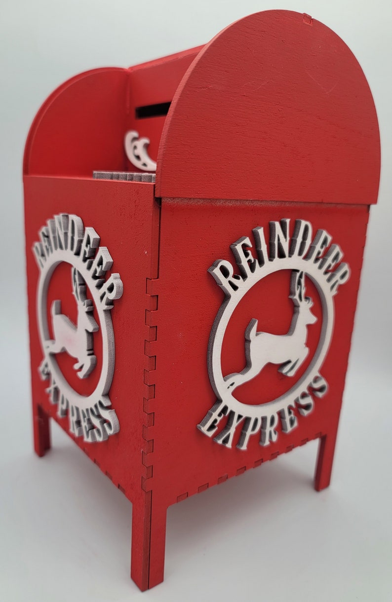 May include: Red wooden reindeer express mailbox with a slot on the top and a white reindeer logo on each side.