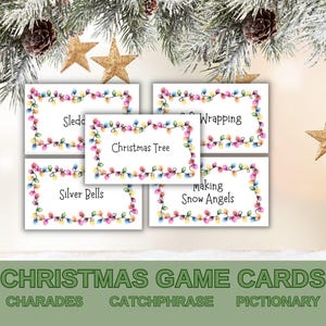 Puede incluir: Cinco tarjetas blancas con un borde de luces navideñas de colores. Cada tarjeta tiene una palabra con temática navideña: Sledding, Wrapping, Christmas Tree, Silver Bells, Making Snow Angels. Debajo de las tarjetas hay una pancarta verde con el texto "CHRISTMAS GAME CARDS" y las palabras "CHARADES", "CATCHPHRASE" y "PICTIONARY".