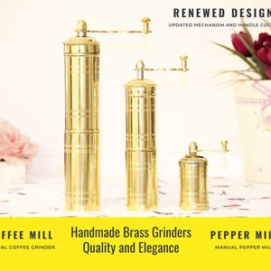 May include: Three brass coffee and pepper mills of varying sizes. The mills have a cylindrical shape with horizontal grooves and a hand crank. The text "RENEWED DESIGN" and "Handmade Brass Grinders Quality and Elegance" are visible.