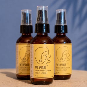 Puede incluir: Tres botellas de vidrio &aacute;mbar de VIVRE Essential Glow Face Serum, cada una con una etiqueta amarilla con un dibujo lineal de una cara. Las botellas tienen tapas de pulverizaci&oacute;n negras y son de 59 ml cada una. El fondo es una pared azul con una sombra.