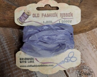 Könnte beinhalten: Eine Rolle gefranstem Band in Lavendelfarbe mit einem Etikett mit der Aufschrift "OLD FASHION RIBBON 1,2m. 1 Stück" und "HANDMADE WITH LOVE www.oldfashionribbon.com".