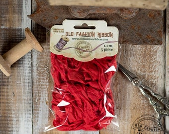 Könnte beinhalten: Rotes, gekräuseltes Band in einem durchsichtigen Plastikbeutel mit einem Etikett, auf dem "Old Fashion Ribbon" und "Handmade with Love" steht. Das Etikett enthält auch die Website-Adresse "www.oldfashionribbon.com" und den Text "1,2 m. 5 Stück".
