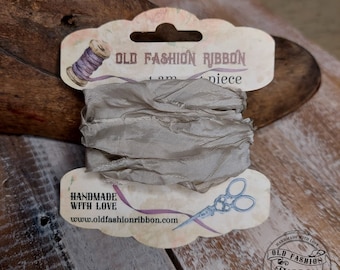 Könnte beinhalten: Eine Spule beigefarbener Seidenband mit einem Etikett, auf dem "OLD FASHION RIBBON" und "HANDMADE WITH LOVE" sowie die Website-Adresse www.oldfashionribbon.com stehen. Das Band ist 10 Meter lang.