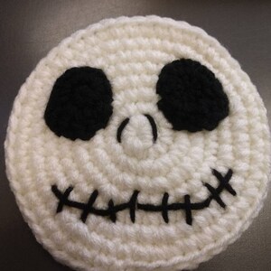 May include: White crocheted Jack Skellington face with black eyes and stitched mouth.