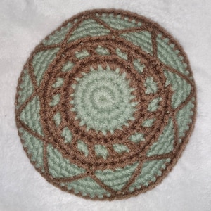 May include: A crocheted kippah with a brown and green geometric pattern.