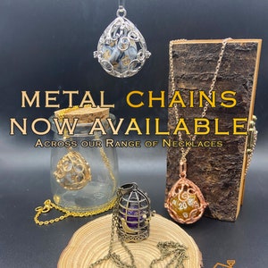 Metal chains now available. An assortment of pendant necklaces displaying the colours of metal chains available: silver, antique bronze and gold. Each pendant has a removable D20 dice inside.