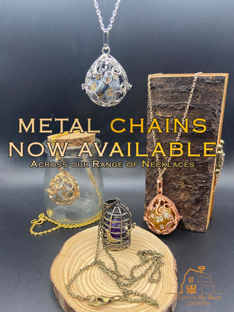 Metal chains now available. An assortment of pendant necklaces displaying the colours of metal chains available: silver, antique bronze and gold. Each pendant has a removable D20 dice inside.