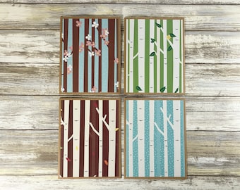 May include: Four different patterned cards with a birch tree design. The cards feature a brown and blue pattern with pink flowers, a green and white pattern with green leaves, a brown and white pattern with orange leaves, and a blue and white pattern with white dots.