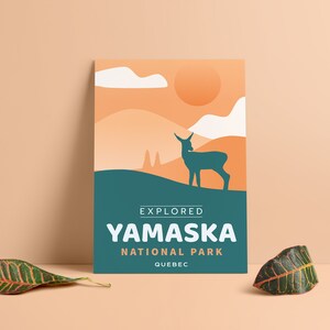 May include: A poster featuring a stylized landscape with a deer silhouette. The poster has an orange and teal color scheme, with the text "EXPLORED YAMASKA NATIONAL PARK QUEBEC". The design evokes a sense of nature and travel.