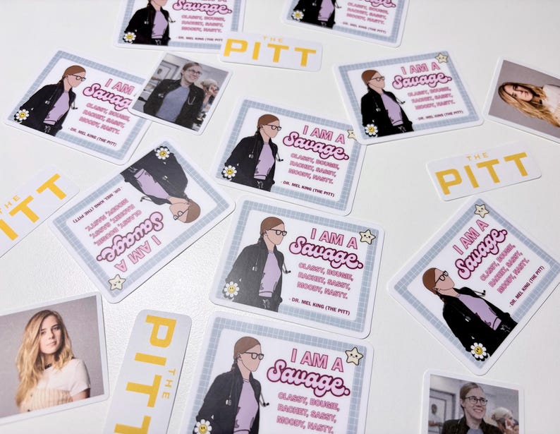 Op de afbeelding: Een verzameling stickers en kleine kaarten met illustraties en tekst. De vierkante stickers tonen een vrouw in een labjas met de tekst "I AM A Savage". Het woord "PITT" is ook zichtbaar op sommige items.
