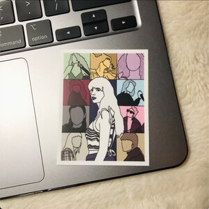 May include: A sticker featuring a collage of nine outlined figures, each with a different colored background. The central figure is a woman with long blonde hair, wearing a striped top and a necklace. The sticker is printed on white paper.