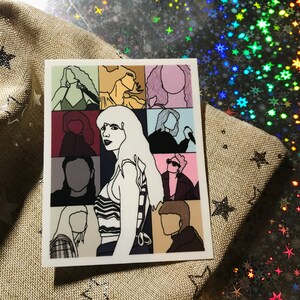 May include: A sticker with a collage of nine different portraits of people. The portraits are in a grid pattern and are all in black and white. The portraits are of different people, including a woman with long hair, a man with a beard, and a woman with short hair.