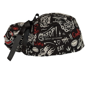 May include: Black scrub hat with a white and red graphic print featuring the words "Break the Chain", "Stop!", "Eat", "Love", and "Cruella".