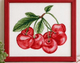 Puede incluir: Un bordado de punto de cruz de un racimo de cerezas de color rojo brillante con hojas verdes, sobre un fondo de tela blanca. La obra está enmarcada en un marco de madera sencillo de color rojo sólido que combina con las cerezas.