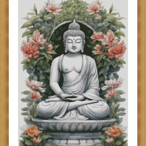May include: A white stone statue of Buddha sitting in meditation pose with his hands in his lap. The statue is surrounded by pink flowers and green leaves.