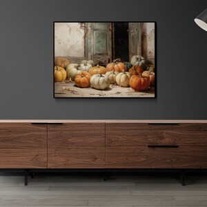 Puede incluir: Una pintura de bodeg&oacute;n con una colecci&oacute;n de calabazas en varios tonos de naranja, amarillo y blanco. Las calabazas est&aacute;n dispuestas en un suelo de madera frente a una puerta abierta.