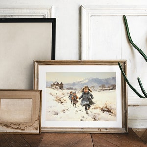Peut inclure: Une peinture encadr&eacute;e repr&eacute;sentant des enfants courant dans un paysage enneig&eacute;. La peinture est dans un cadre en bois clair et est accroch&eacute;e &agrave; un mur blanc. Il y a un cactus en pot &agrave; droite de la peinture.