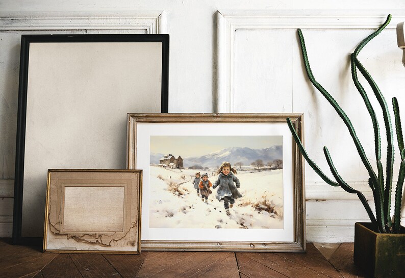 Peut inclure: Une peinture encadr&eacute;e repr&eacute;sentant des enfants courant dans un paysage enneig&eacute;. La peinture est dans un cadre en bois clair et est accroch&eacute;e &agrave; un mur blanc. Il y a un cactus en pot &agrave; droite de la peinture.