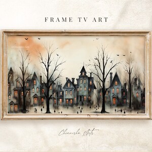 May include: A framed watercolour painting depicting a row of houses with illuminated windows at dusk. The houses are surrounded by bare trees and there are small figures walking in front of them. The sky is a soft orange and yellow.
