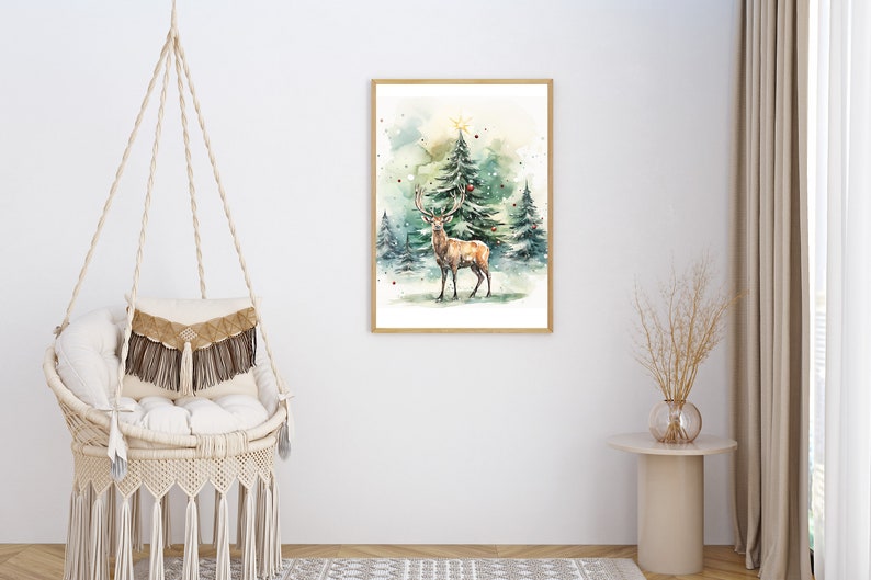 以下が含まれることがあります： 雪の森の鹿の水彩画、明るい木で額装されています。このアートワークは、常緑樹の前に立っている大きな角を持つ雄大な鹿を特徴としています。シーンは冬に設定され、一番高い木の上に星があります。