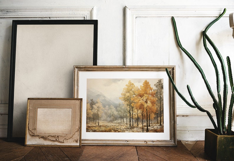 K&ouml;nnte beinhalten: Drei gerahmte Bilder h&auml;ngen an einer wei&szlig;en Wand. Das mittlere Bild ist ein Landschaftsgem&auml;lde eines Waldes mit B&auml;umen in Herbstfarben. Das Bild links ist eine leere Leinwand. Das Bild rechts ist eine leere Leinwand.