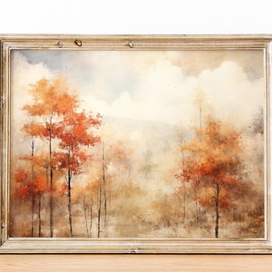 May include: A framed watercolor painting of a forest scene with trees in shades of orange, brown, and yellow. The background is a hazy blue and white, suggesting a cloudy sky.