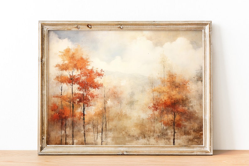 May include: A framed watercolor painting of a forest scene with trees in shades of orange, brown, and yellow. The background is a hazy blue and white, suggesting a cloudy sky.