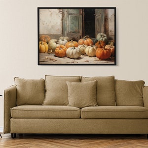 Puede incluir: Una pintura enmarcada que representa una naturaleza muerta con una colecci&oacute;n de calabazas en varios tonos de naranja, amarillo y verde. Las calabazas est&aacute;n dispuestas en un suelo de madera frente a una puerta entreabierta.