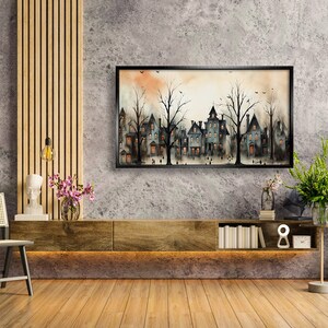 May include: A watercolour painting depicting a row of houses with trees in front of them. The houses are painted in shades of grey and blue, and the trees are painted in shades of green and brown. The painting is framed in black and is hanging on a grey wall.