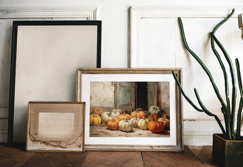 Puede incluir: Una pintura enmarcada que representa una naturaleza muerta con una colecci&oacute;n de calabazas en varios tonos de naranja, amarillo y blanco. Las calabazas est&aacute;n dispuestas en un suelo de madera frente a una puerta con una puerta verde descolorida.