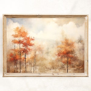 May include: A framed painting of a forest scene with trees in shades of orange, red, and brown. The background is a hazy blue and white, suggesting a cloudy sky. The painting is in a simple, light wood frame.