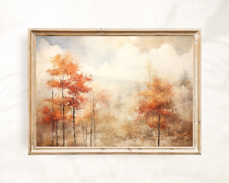 May include: A framed painting of a forest scene with trees in shades of orange, red, and brown. The background is a hazy blue and white, suggesting a cloudy sky. The painting is in a simple, light wood frame.
