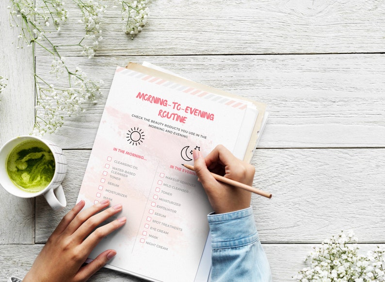 May include: A checklist on a white sheet of paper with a pink watercolor background. The checklist is titled "Morning-to-Evening Routine" and includes a list of beauty products to use in the morning and evening. The checklist is divided into two sections: "In the Morning..." and "In the Evening..." The checklist includes items such as cleansing oil, water-based cleanser, toner, serum, moisturizer, mask, and night cream.