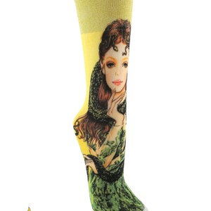 Könnte beinhalten: Gelbe und grüne Socken mit einem Frauenkopf und einer Schlange auf der Vorderseite.