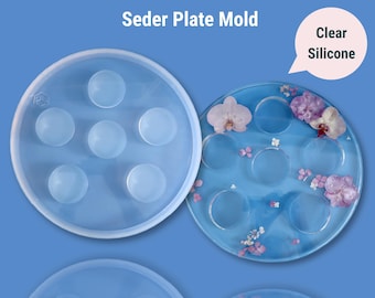 May include: Clear silicone mold for making a Seder plate. The mold has seven round indentations for the traditional Seder plate items. The mold is shown next to a finished Seder plate with dried flowers.