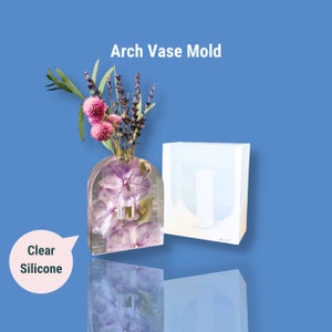 May include: Clear silicone mould for making a vase with an arched top. The mould is shown with a finished vase filled with dried flowers.