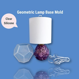 May include: Geometric lamp base mould made of clear silicone. The mould is shaped like a geometric shape, similar to a diamond. The mould is shown with a finished lamp base made of purple resin.