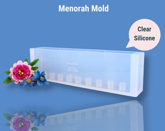 May include: Clear silicone mold for making a menorah. The mold is rectangular and has seven individual candle holders. The mold is made in China.