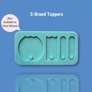 May include: A light blue silicone mold with four cavities for making resin toppers. The mold has a rounded circle, a banner shape, and two rectangular shapes. The mold is labeled "MODERN MOLD".