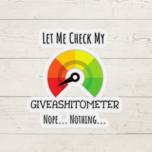 Könnte beinhalten: Ein weißer Aufkleber mit einer bunten Anzeige, die "Giveashitometer" anzeigt, wobei eine Nadel auf den roten Bereich "Nope... Nothing..." zeigt. Der Text "Let me check my" befindet sich über der Anzeige.