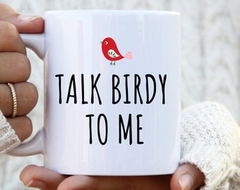 May include: White ceramic mug featuring a red bird illustration and the text "Talk Birdy To Me" in black.