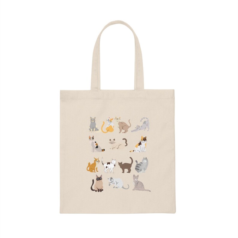 May include: A beige tote bag with a design of various cats in different poses and colors. The cats are arranged in a grid pattern on the bag.