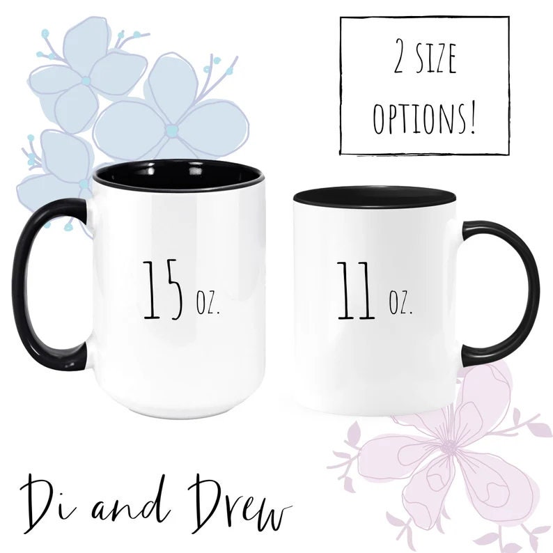 May include: Two white ceramic mugs with black rims and handles. The mug on the left is 15 ounces and the mug on the right is 11 ounces. The text "Di and Drew" is printed below the mugs.