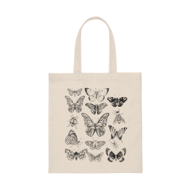 Puede incluir: Una bolsa de lona natural con un estampado en blanco y negro de varias mariposas e insectos. El estampado presenta una variedad de especies de mariposas, incluyendo monarcas, swallowtails y damas pintadas.