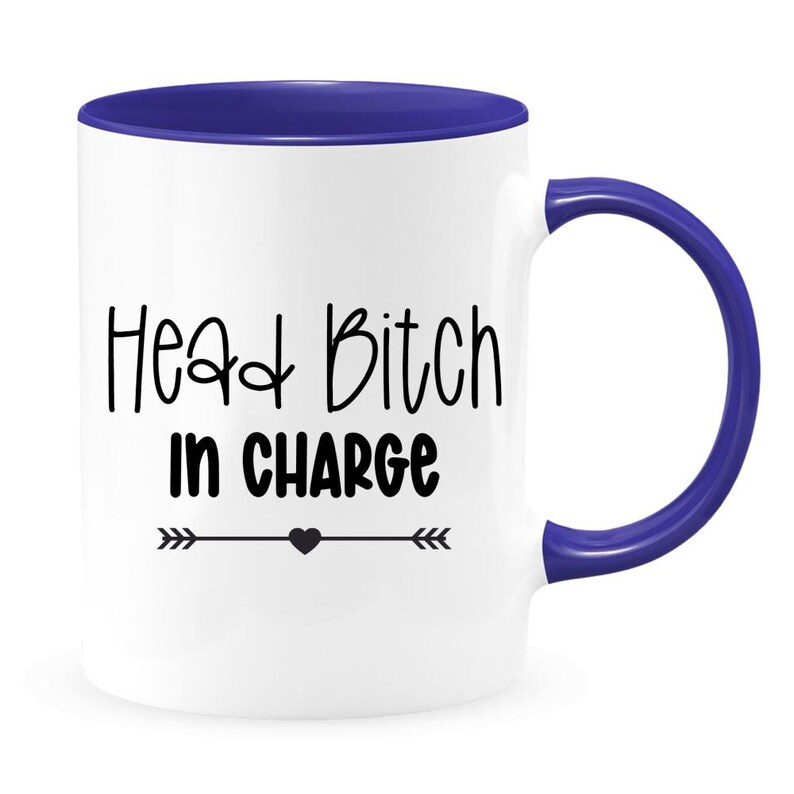 May include: White ceramic mug with a blue rim and handle. The mug has black text that reads "Head Bitch in Charge" with a small heart and arrows on either side.