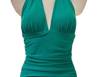 May include: A teal halter-style swimsuit with a deep V-neckline and a ruched skirt.