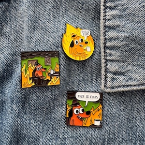 May include: Three enamel pins featuring the This Is Fine dog meme. One pin is circular with the dog in flames holding a mug. Two square pins show the dog sitting in a burning room with a speech bubble that reads THIS IS FINE in black text.