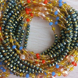 Puede incluir: Primer plano de un collar de cuentas multicadena con cuentas de color verde oscuro, dorado, naranja y azul. El collar est&aacute; hecho de cuentas de varios tama&ntilde;os y formas, creando un aspecto texturizado y en capas.